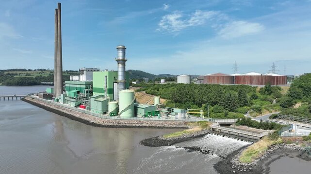 Wide aerial shot of an electricity generating facility overlooking the River Suir estuary in County Wexford, Ireland, under clear daylight skies.