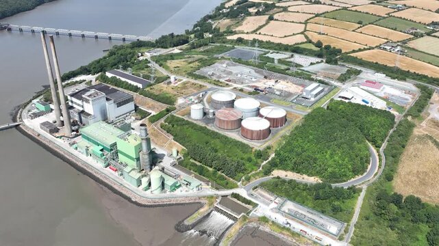 Aerial drone view of an electricity power plant on the River Suir in County Wexford, Ireland, showcasing industrial energy infrastructure beside the scenic estuary.