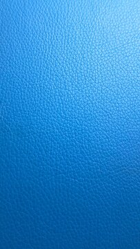 Blue textured leather surface with fine natural grain pattern and soft gradient lighting