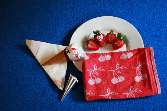 Helado cono de cucurucho, fresa natural, plato, trapo y servilleta con fondo azul ice cream strawberry blue background