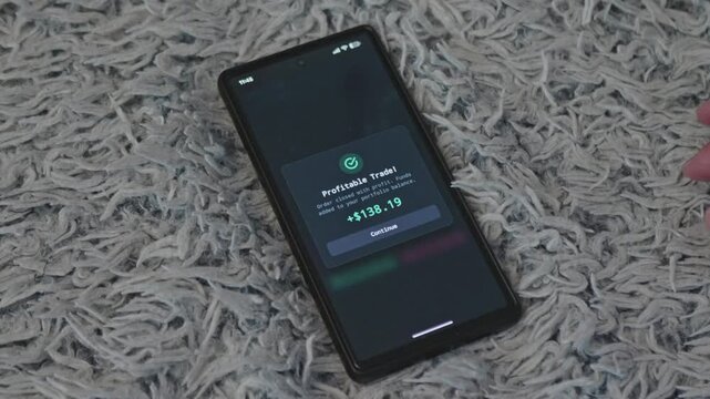 Investor hand tapping smartphone screen displaying profitable trade notification with added funds, ideal for online trading success, crypto profit, and financial achievement videos.