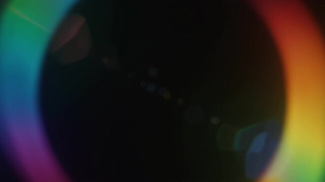 Rainbow light dispersion shifts softly through deep black, blending spectrum colors at delicate edges with luminous optical glow, dreamy scientific atmosphere, and fluid cinematic motion.