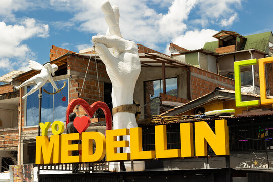Medell&iacute;n, Antioquia, Colombia - June 29, 2026 - Urban art featuring yellow letters forming the message I Love Medell&iacute;n, with a heart held by a large hand in Comuna 13