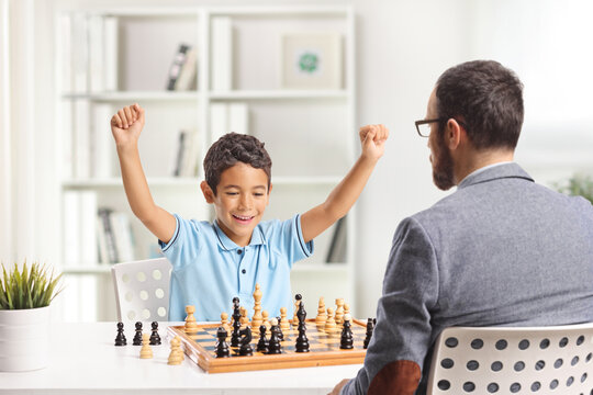 Boy beating his father in a chess game