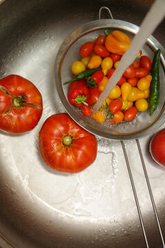 Fresh Homegrown Tomatoes Being Washed Under Running Water in Kitchen Sink, Healthy Food Preparation