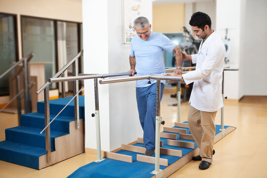 Physiotherapist helping patient to walk