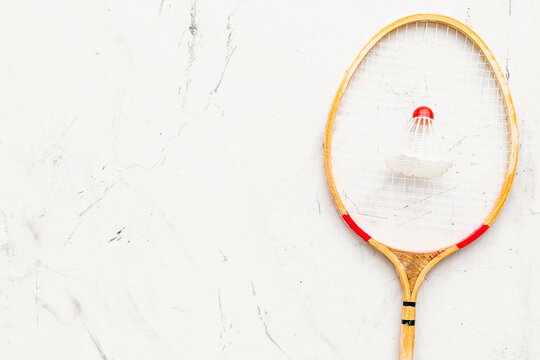 Badminton concept. Badminton racket and shuttlecock on white stone background top view space for text