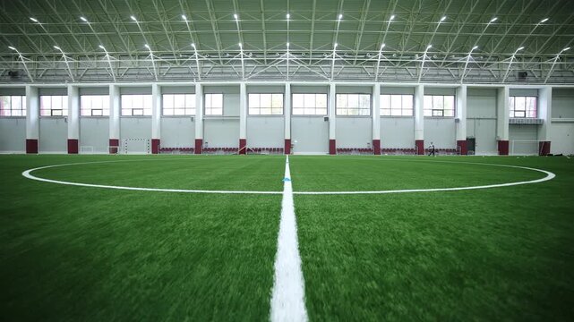 Clean soccer pitch with white markings and rows of seats awaits for competitions. Empty facility waits for athletes before match