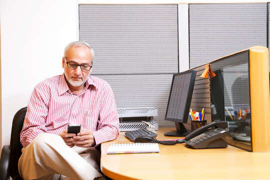 Senior executive reading sms on mobile phone