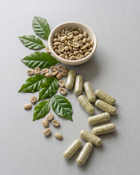 Green coffee extract capsules and a bowl of green coffee beans in a premium composition.