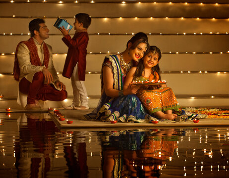 Family arranging diyas
