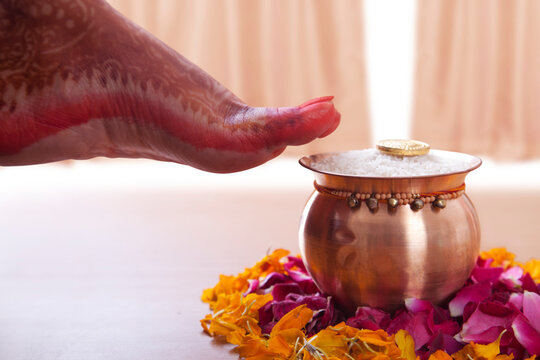 Grihapravesh of bride about to overturn kalash of rice on threshold