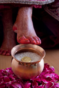 Grihapravesh of bride about to overturn kalash of rice on threshold