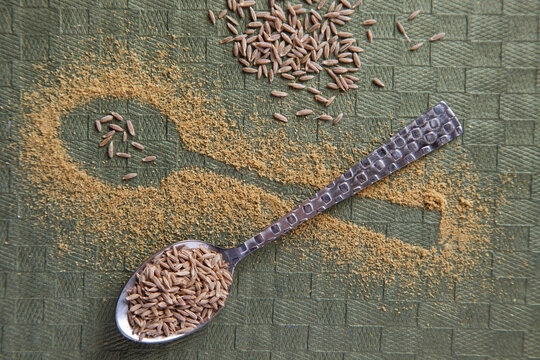 Shape of a spoon in randomly scattered cumin powder and cumin seeds on spoon