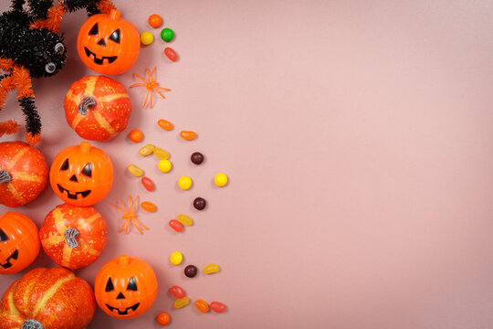 Halloween pumpkin decorations and candies flat lay with copy space