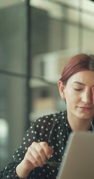 Businesswoman with eye pain in office