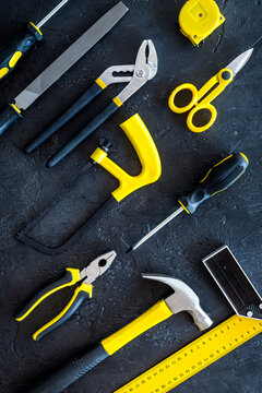 constructor desk pattern with set of building implements dark desk background top view