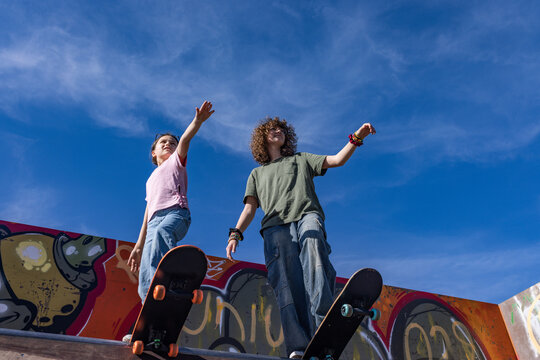 Teenage sisters balance on skateboards at an outdoor skatepark