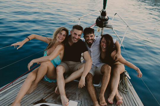 Happy friends enjoy a summer sailing vacation on a boat in Ibiza