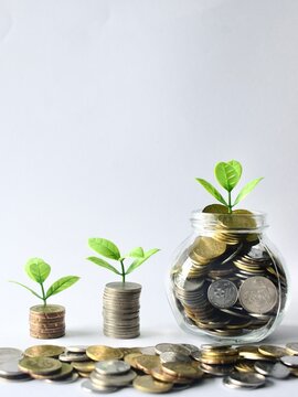 Close-up macro view of Malaysian sen coins scattered around growing stacks and a glass savings jar, highlighting regional currency and detailed financial investment concepts.