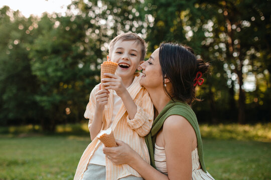 A mother and son eat ice cream in the park