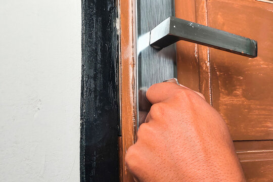 A hand is opening the door with a key.