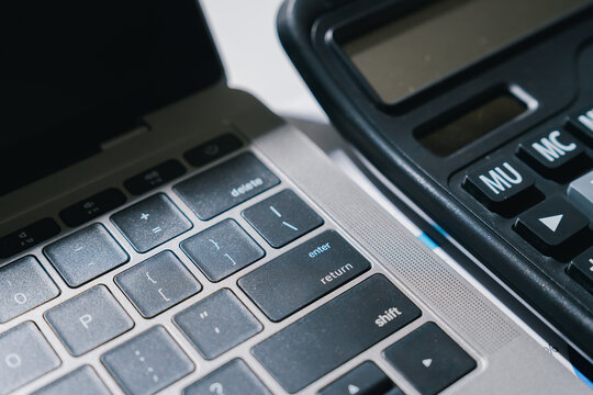 Laptop computer keyboard and black calculator professional equipment feel focused and serious for productive work in modern office space