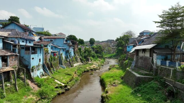 Aerial Dolly Along River Through Kampung Biru Arema Blue Village in Malang East Java Indonesia
