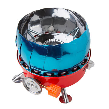 Folded portable camping gas stove with wind shield isolated on white background. Compact hiking burner stove with blue protective film