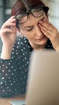 Businesswoman with eye pain at the office