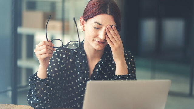 Businesswoman with eye pain at the office