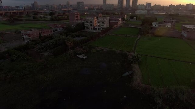 Fast Dynamic Orbit Drone Shot of Cairo Egypt Nile Riverfront Green Fields and Houses Golden Hour Sunrise Dynamic Circling DJI Raw Not Color Graded