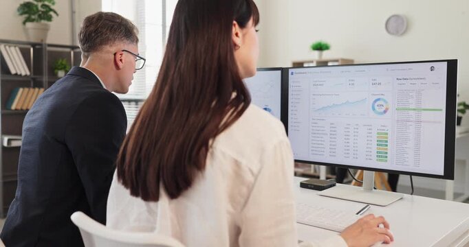 Analysts team in office using analytics dashboard. They monitor finance data on a computer track charts and KPIs, and create reporting for planning. Clear analytics monitoring business concept.