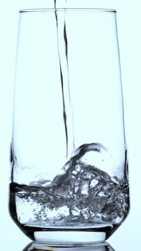 Pure drinking water filling a transparent glass with smooth pouring motion.