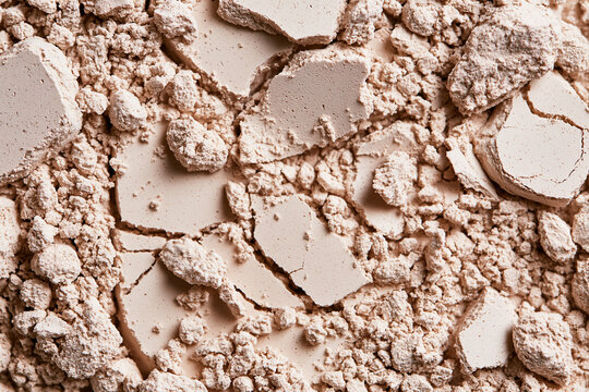 Texture of broken and crumbled light beige makeup powder
