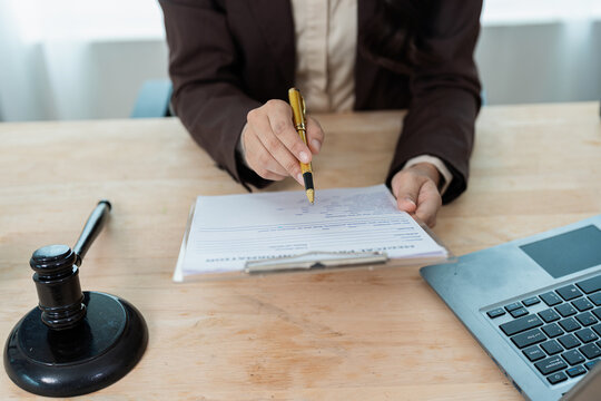 Female attorney explaining legal contract or health insurance claim document to client at office
