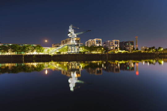 Modern new build properties by the water in Offenbach am Main harbor bey night, Hesse: Development of a new residential area in a city with condominiums and apartments