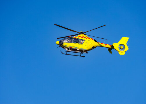 Helicopter rescue Yellow helicopter in the air while flying on blue sky.