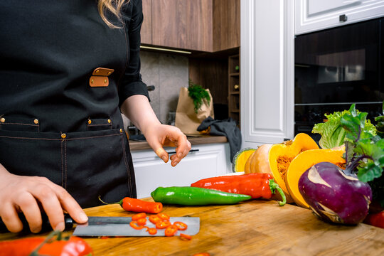 Woman chef hands cutting red chili pepper wooden board kitchen. Healthy vegan vegetarian raw food culinary concept.