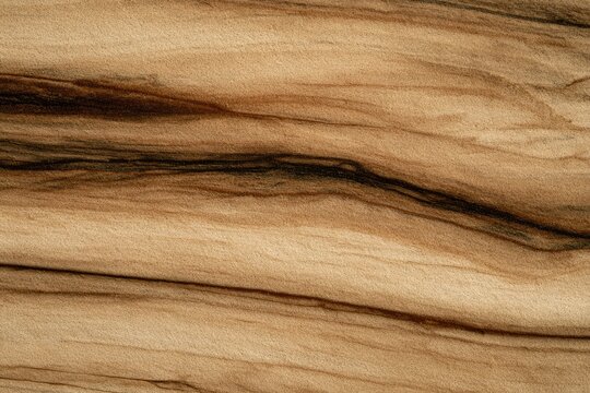 Close-up of light-colored wood grain with dark, swirling patterns and fine texture