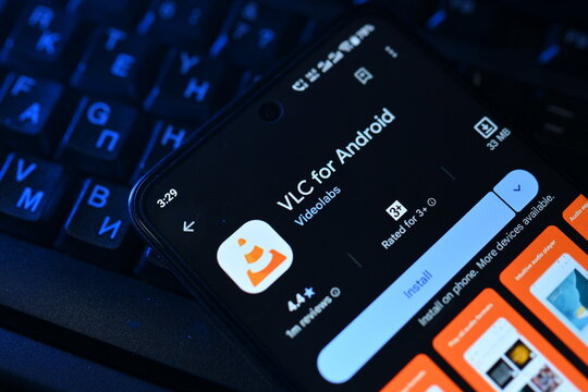 VEHARI, PAKISTAN - JULY, 30, 2026: VLC download page on smartphone screen next to a backlit computer keyboard