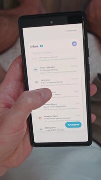 Close up of man hands scrolling through email inbox interface on smartphone, checking work messages, corporate communication concept Vertical video. 
