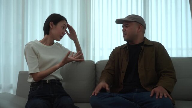 Moment of Heartbroken couple sitting apart after an unresolved family conflict. Relationship challenges, emotional stress. Communication breakdown, financial pressure. Mental wellbeing marriage.
