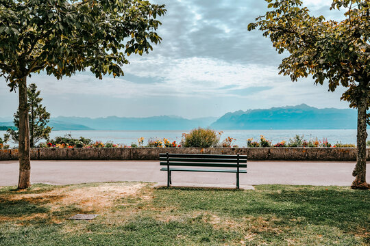 Banc public vide sur la promenade du lac L&eacute;man face aux Alpes &agrave; Morges