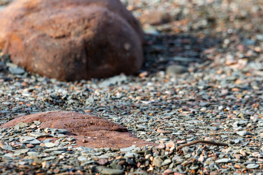 Quebec, Canada, 28 June 2026 : Reddish-brown rocks and small pebbles cover a natural ground surface.