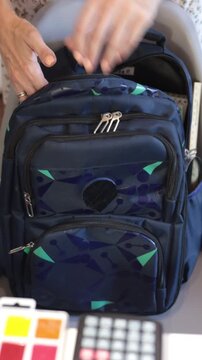 Packed blue backpack with colorful school supplies and stationery, student preparation, organized learning, daily education, school routine.