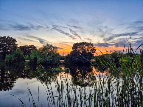 Beautiful sunset with reflection on water at Iremongers Pond in Nottingham, UK