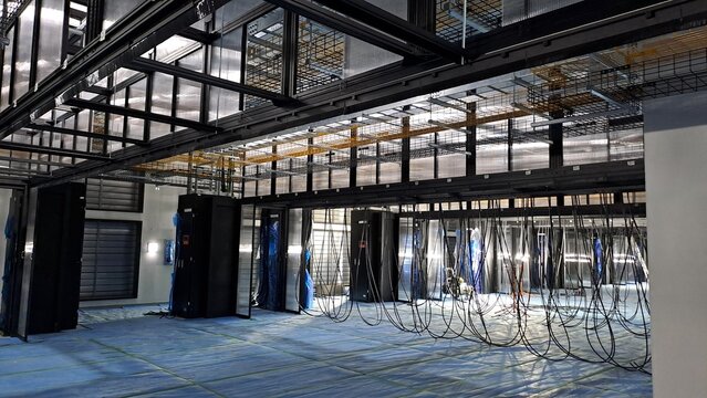 Data center server room under construction with containment systems, cable trays, and electrical cable installation