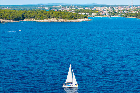 Aerial view of a white sailboat cruising across Adriatic Sea near Pula Croatia
