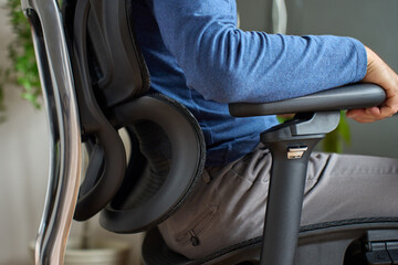 Person adjusting armrest on ergonomic office chair